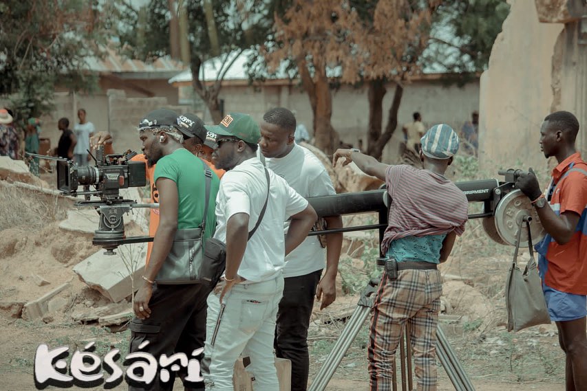 Production crew coordinating camera equipment and dolly track on the set of Kesari